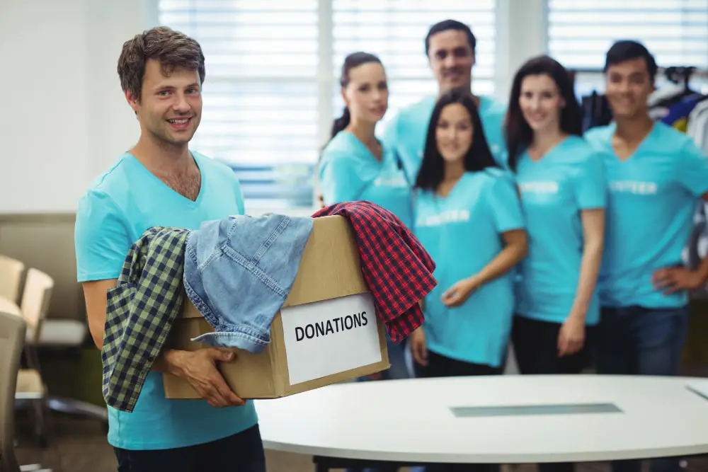 Volunteer Standing with box to donates clothes